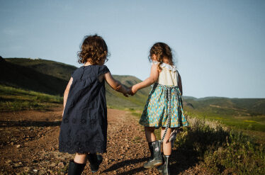 young children holding hands in a field
