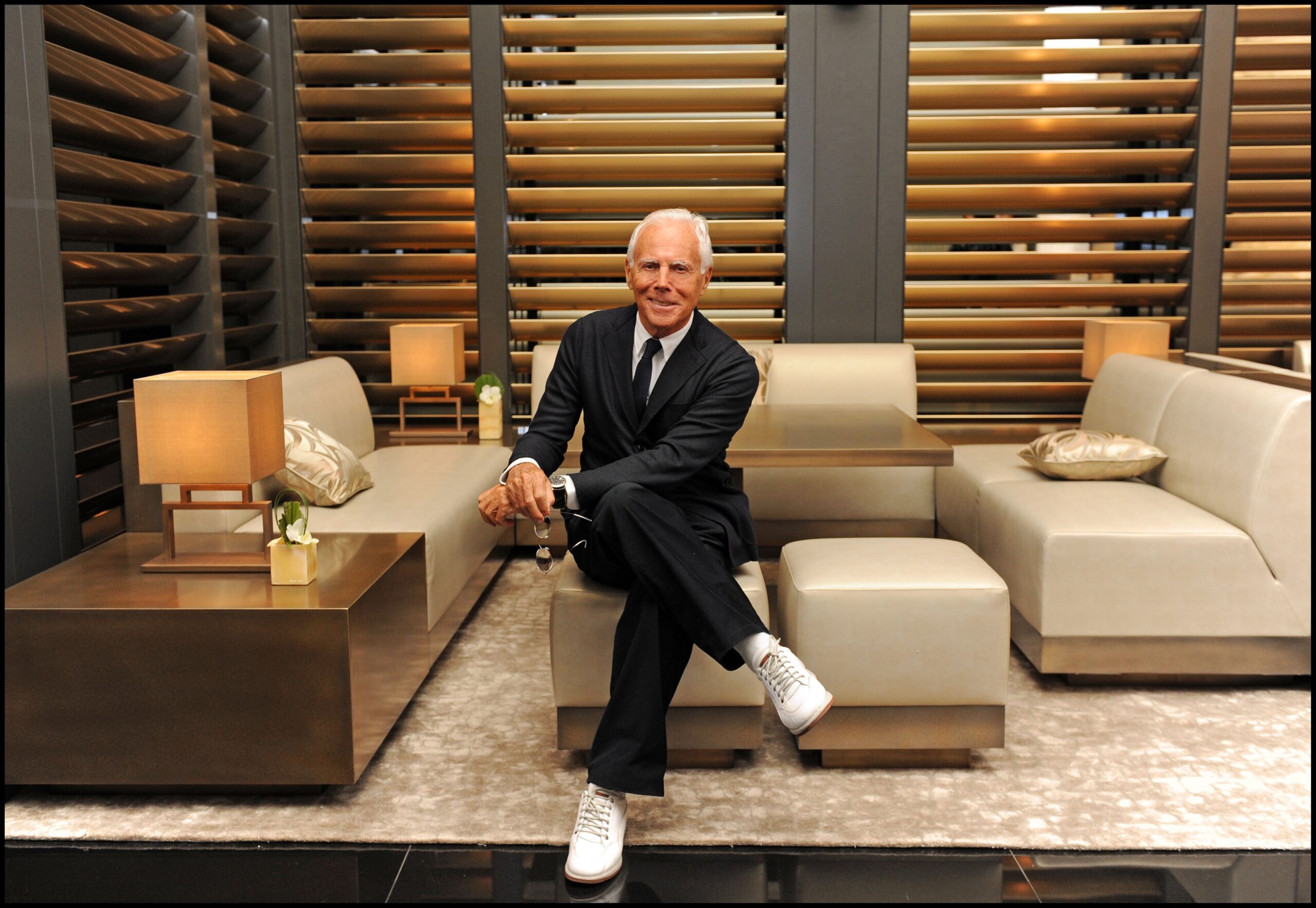 Giorgio Armani sitting in his boutique.