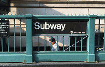 Man walking down New York City subway stairs into station