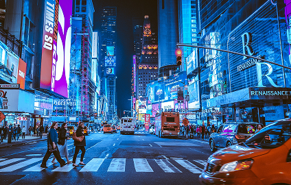 Times Square at night in New York City with illuminated billboards and traffic