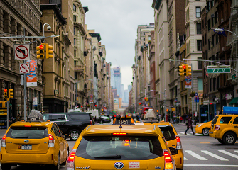 midtown new york city intersection with taxis and pedestrians