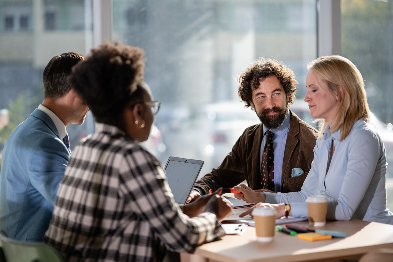 Professionals working together, discussing ideas and planning strategy in a modern office environment. Emphasizing teamwork and communication