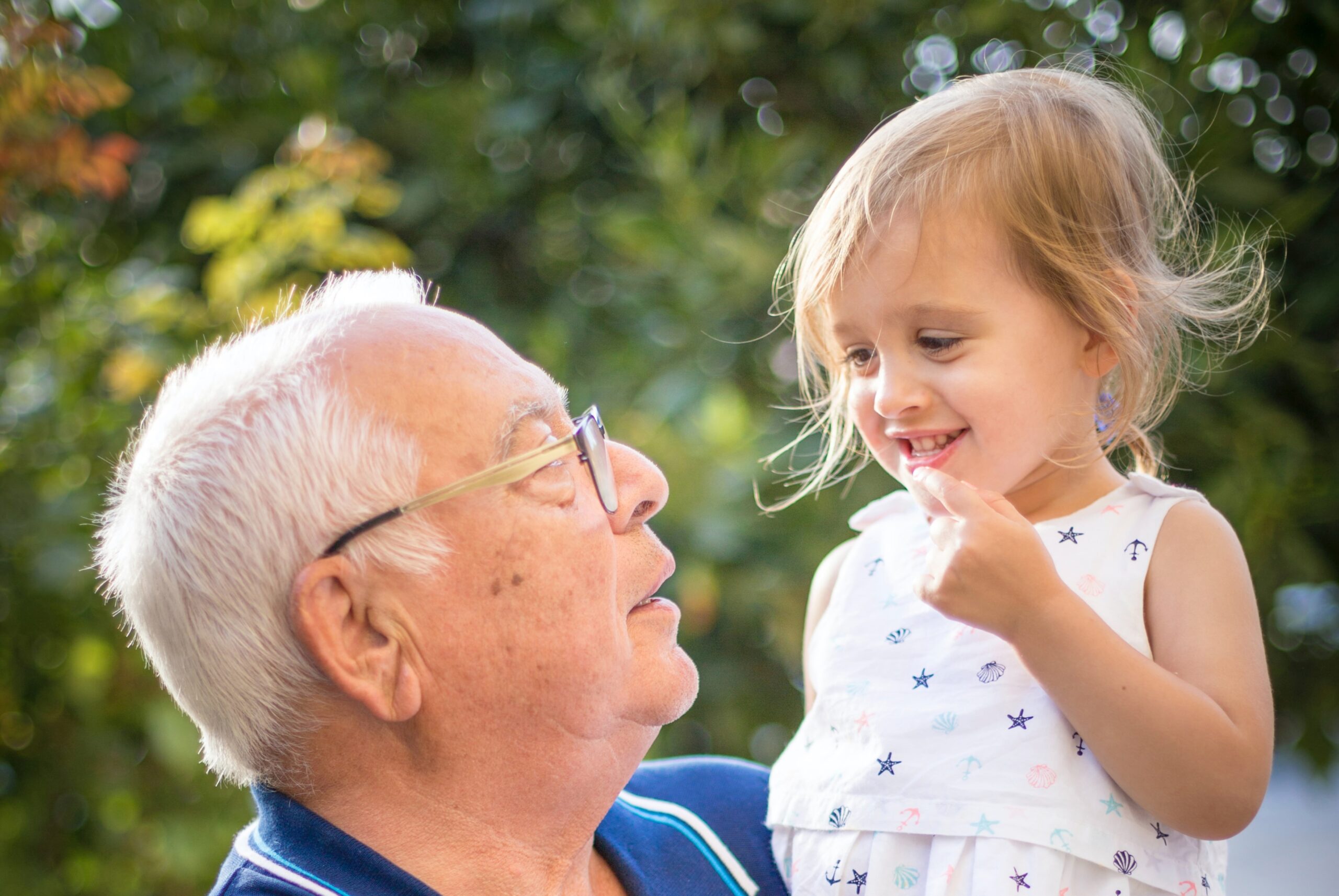 Grandfather smiling and holding his young grandchild